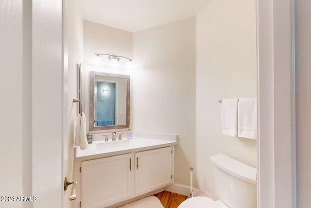 bathroom with vanity, wood-type flooring, and toilet