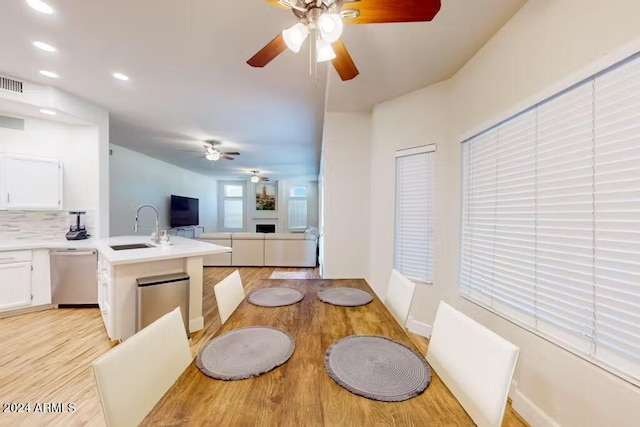 dining room with sink, light hardwood / wood-style flooring, and ceiling fan