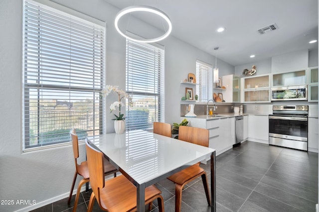 dining space with sink and dark tile patterned flooring