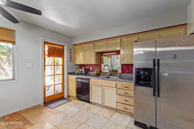 kitchen featuring stainless steel fridge, sink, decorative backsplash, black dishwasher, and a healthy amount of sunlight