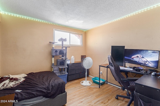 bedroom featuring a textured ceiling and light hardwood / wood-style floors