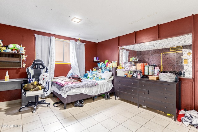 bedroom featuring light tile patterned flooring and a textured ceiling