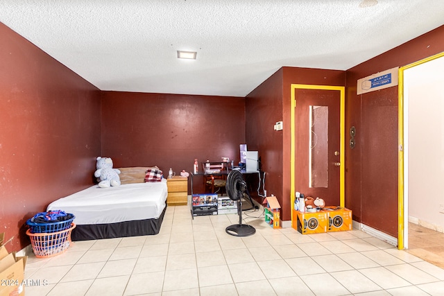 bedroom with light tile patterned floors and a textured ceiling