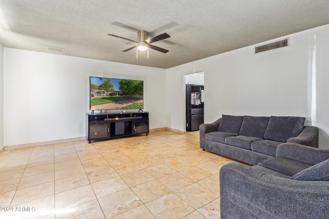 tiled living room with ceiling fan and a textured ceiling