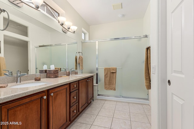 bathroom with a shower with door, vanity, and tile patterned floors