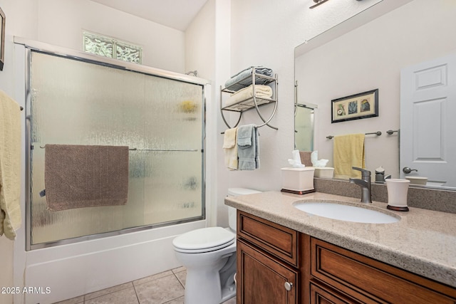 full bathroom featuring vanity, combined bath / shower with glass door, tile patterned floors, and toilet