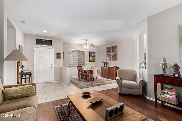 living room with ceiling fan and light hardwood / wood-style flooring