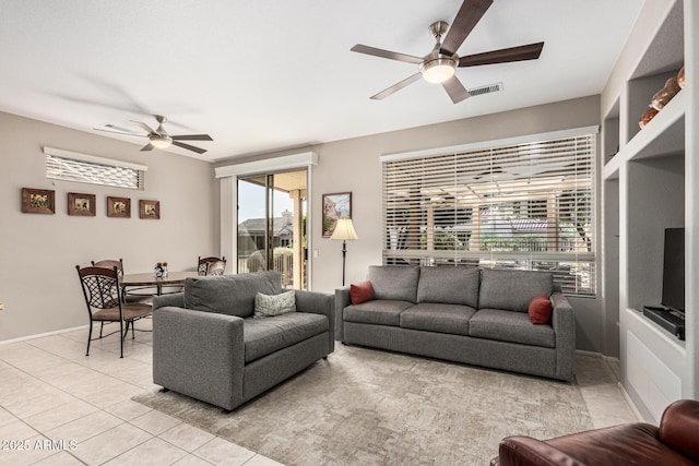 living room with light tile patterned floors, built in shelves, and ceiling fan