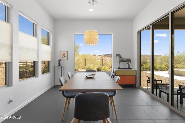 tiled dining area with plenty of natural light and a chandelier