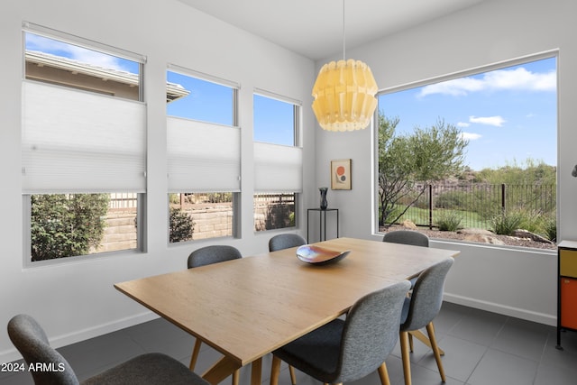 dining room featuring dark tile patterned flooring and a wealth of natural light