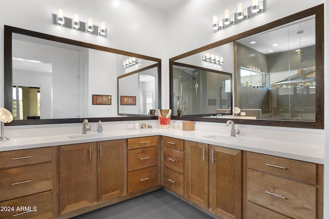 bathroom with a shower with door, vanity, and tile patterned flooring