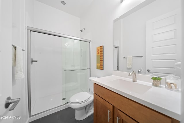 bathroom featuring toilet, tile patterned floors, an enclosed shower, and vanity