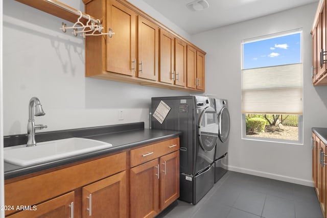 laundry room with a healthy amount of sunlight, tile patterned floors, washing machine and dryer, cabinets, and sink