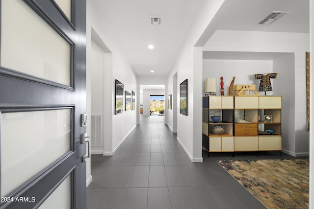 hallway with dark tile patterned flooring