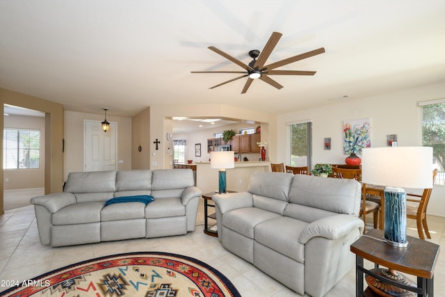 living room with ceiling fan, plenty of natural light, and light tile patterned flooring