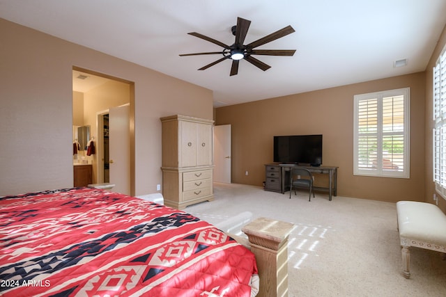 carpeted bedroom with ensuite bathroom and ceiling fan