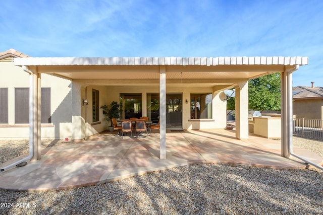 rear view of house with a patio and exterior kitchen