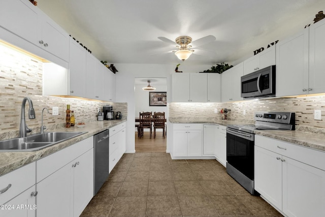 kitchen featuring sink, backsplash, white cabinetry, and stainless steel appliances