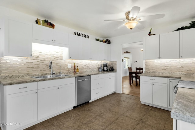 kitchen featuring dishwasher, dark tile patterned floors, sink, white cabinets, and tasteful backsplash