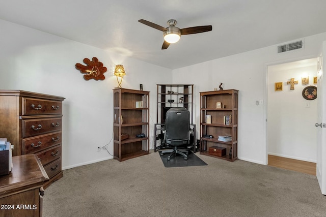 carpeted office space featuring ceiling fan