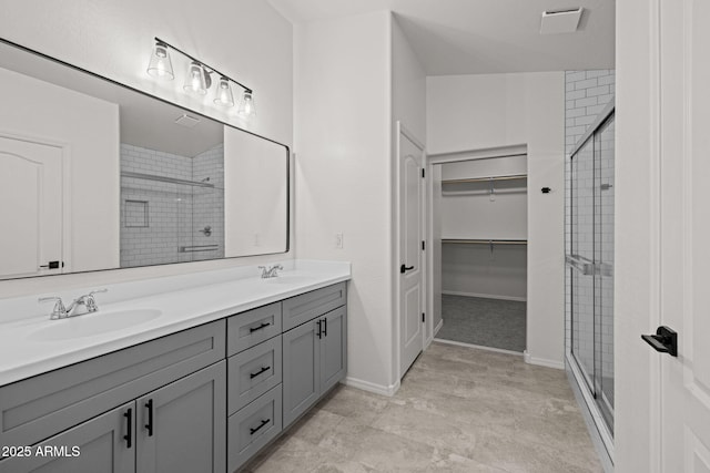 3843 E Citrine Rd, San Tan Valley, AZ 85143 - bathroom featuring a stall shower, double vanity, a spacious closet, and baseboards
