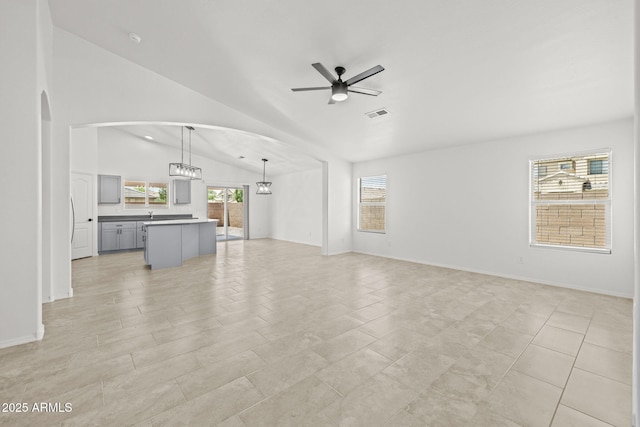 3843 E Citrine Rd, San Tan Valley, AZ 85143 - unfurnished living room featuring a ceiling fan, vaulted ceiling, arched walkways, and baseboards