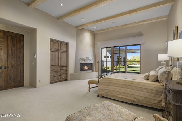 bedroom featuring beam ceiling, a large fireplace, carpet floors, and access to outside