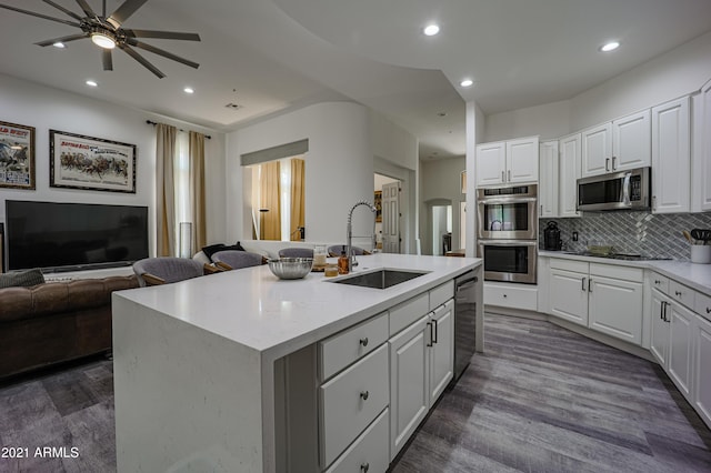 kitchen with sink, white cabinets, stainless steel appliances, and a kitchen island with sink