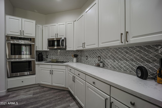 kitchen with white cabinetry, decorative backsplash, dark hardwood / wood-style floors, and appliances with stainless steel finishes