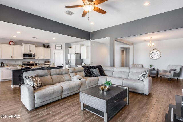 living room featuring sink, ceiling fan with notable chandelier, and hardwood / wood-style floors