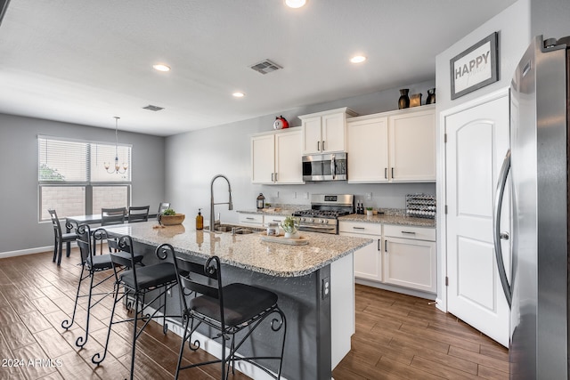 kitchen featuring white cabinetry, stainless steel appliances, an island with sink, sink, and dark wood-type flooring