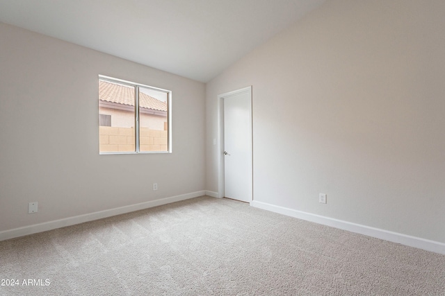 unfurnished room featuring light carpet and lofted ceiling