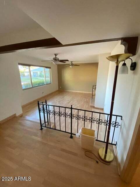 empty room featuring wood finished floors, ceiling fan, and baseboards