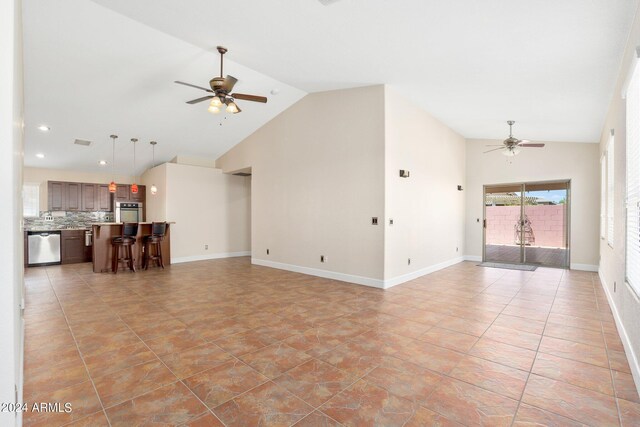 unfurnished living room with ceiling fan and high vaulted ceiling