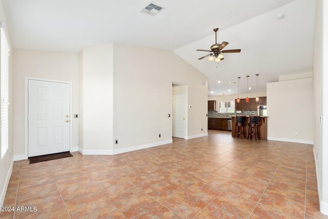 unfurnished living room with high vaulted ceiling and ceiling fan