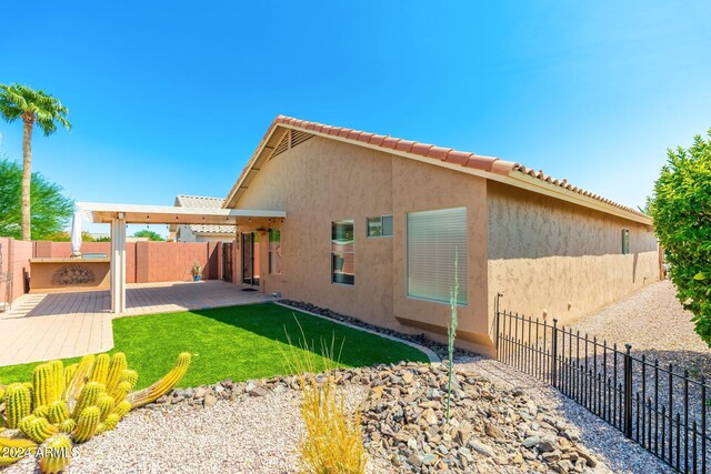 rear view of property featuring a lawn and a patio