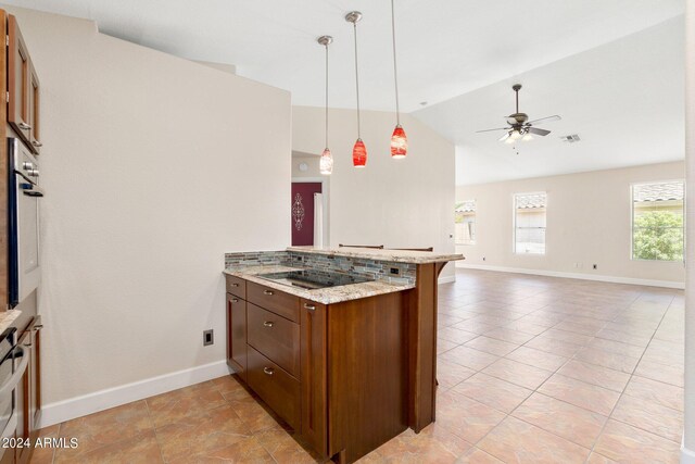 kitchen featuring ceiling fan, light stone counters, kitchen peninsula, decorative light fixtures, and vaulted ceiling