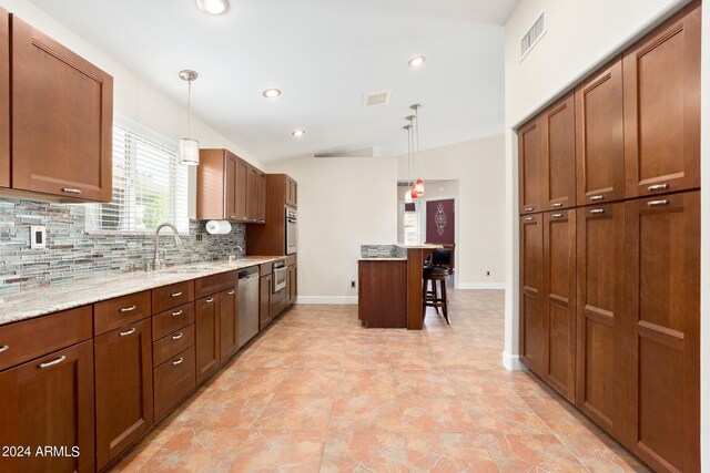 kitchen with a breakfast bar, stainless steel appliances, hanging light fixtures, and tasteful backsplash