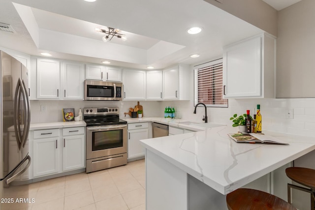 12222 N Paradise Village Pkwy S Unit 237, Phoenix, AZ 85032 - kitchen with appliances with stainless steel finishes, a peninsula, decorative backsplash, light stone counters, and recessed lighting