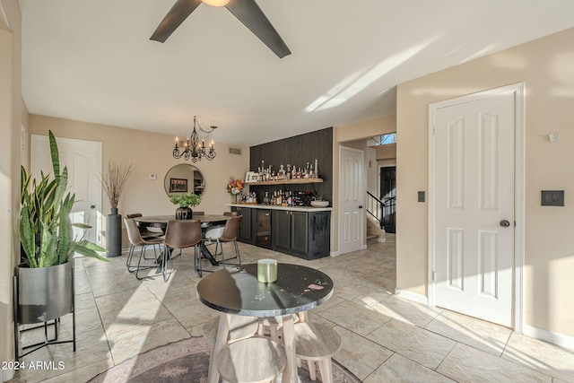 dining space with ceiling fan with notable chandelier