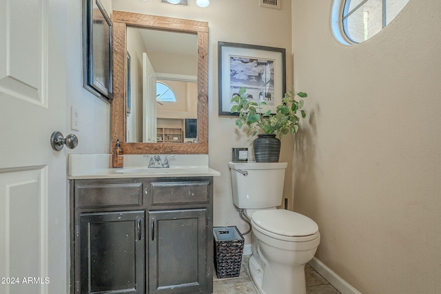 bathroom featuring tile patterned flooring, vanity, and toilet