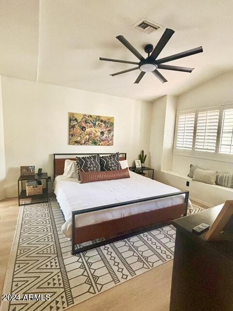 bedroom with ceiling fan, light wood-type flooring, and lofted ceiling