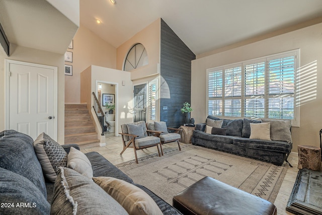 living room with light hardwood / wood-style floors and high vaulted ceiling