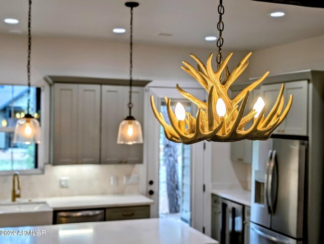 kitchen with stainless steel fridge with ice dispenser, decorative backsplash, dishwasher, sink, and decorative light fixtures