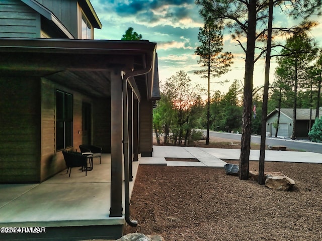 yard at dusk featuring a garage and an outdoor structure