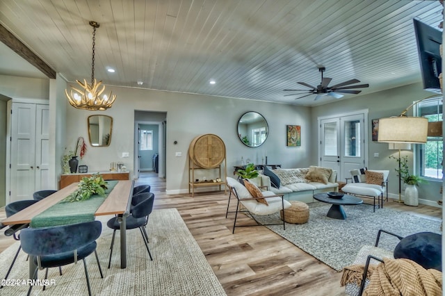 living room with light hardwood / wood-style flooring, ceiling fan with notable chandelier, and wooden ceiling