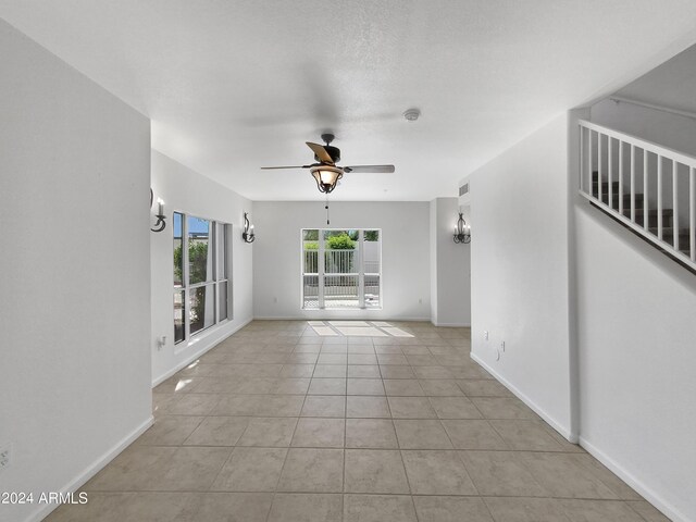 empty room featuring ceiling fan and light tile patterned flooring