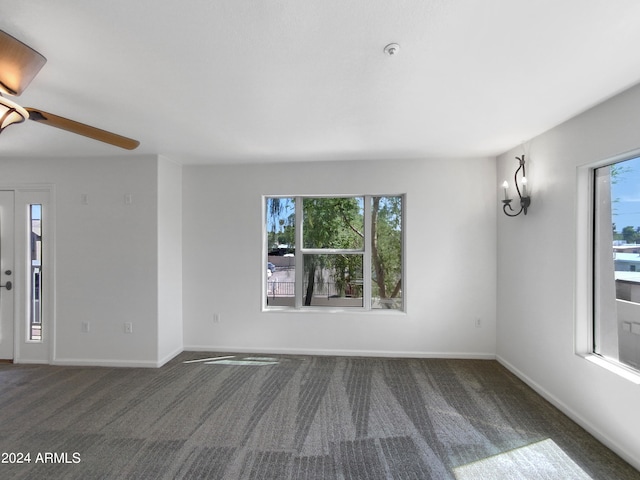 carpeted spare room with ceiling fan and a wealth of natural light