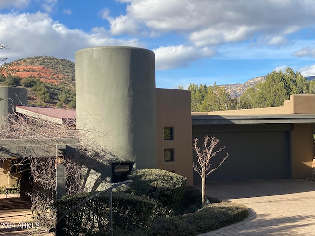 view of property exterior featuring a garage and a mountain view