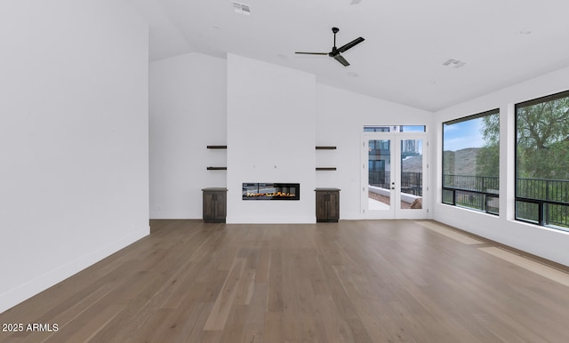 301 E Jomax Rd, Phoenix, AZ 85085 - unfurnished living room with wood finished floors, a glass covered fireplace, a ceiling fan, french doors, and high vaulted ceiling